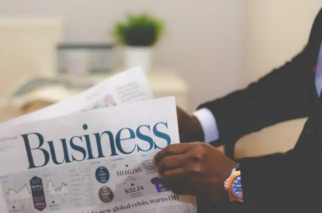 Hands Holding Business Newspaper